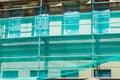 scaffold building renovation construction site.Front exterior view of net wrap scaffolding in front of building at construction Royalty Free Stock Photo