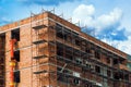 Scaffolding around new unrendered building at construction site