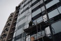 scaffolding being used to repair cracked window on a tall building