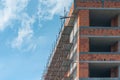 Scaffolding on empty construction site with unfinished incomplete building