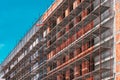 Scaffolding on empty construction site with unfinished incomplete building