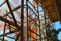 Scaffolding in front of the repaired building is shrouded with construction safety net, view from inside, sunny autumn day Royalty Free Stock Photo