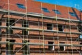 Scaffolding near a high-rise brick house under construction in Germany