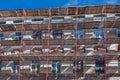 Scaffolding near a house under construction for external plaster works, high apartment building in city, white wall and window, Royalty Free Stock Photo