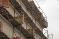 Scaffolding near the wall of the house. Construction of a 4-storey building