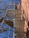 Scaffolding on a residential building with branches of trees touching it