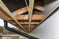 Scaffolding with three rows of wooden battens for attaching the PVC soffit, visible cables for lighting.