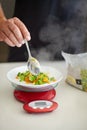 Scale, food and man with vegetables in kitchen to measure portion for calories, nutrition and balance diet. Cooking Royalty Free Stock Photo