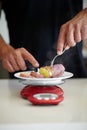 Scale, food and man weigh vegetable in kitchen to measure portion for calories, nutrition and balance diet. Cooking Royalty Free Stock Photo