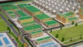 Scale manufacturing campus model featuring storage domes and warehouse rows, logistics manager plotting supply chain Royalty Free Stock Photo