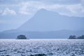 Scale.  Small islet in Johnstone Strait and mountain, Vancouver Island Royalty Free Stock Photo