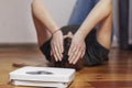 Scales and depressed young woman lying on the floor holding her head and covering her face with her hands Royalty Free Stock Photo