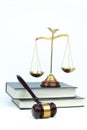 Scales, judge\'s gavel, and books on jurisprudence on a white background. Legal and law concept