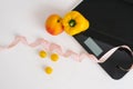 Scales with measuring tape and fruits and vegetables on a white background. The concept of weight loss and health Royalty Free Stock Photo