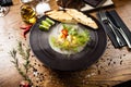 Scallop ceviche served in black bowl with liquid ice smoke