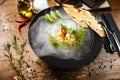 Scallop ceviche served in black bowl with liquid ice smoke