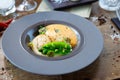 Scallops with shrimp foam, cauliflower cream and green peas on a plate. Delicious healthy seafood closeup served for