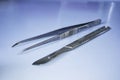 Scalpel and laboratory tweezers on a laboratory table. Labware