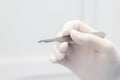 scalpel in the surgeon& x27;s hand close-up. a sterile glove on the hand. Royalty Free Stock Photo