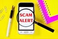 Scam alert-a message on the smartphone screen. Fraud is theft or acquisition of the right to another`s property by deception or