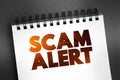 Scam Alert text on notepad, concept background Royalty Free Stock Photo