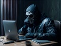 A scammer in a mask sits in front of a laptop.