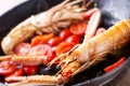 Scampi, preparation and cooking in a pan. Shellfish scampi cooked in a pan with cherry tomatoes