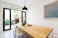 Scandi styled dining room interior with outlook to courtyard via Royalty Free Stock Photo