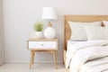 Scandinavian bedside tables decorate a modern bedroom with calm white tones and light wood