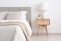 Scandinavian bedside tables decorate a modern bedroom with calm white tones and light wood