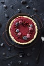 Scandinavian cuisine. Homemade lingonberry tart with frozen wild berries in vintage metal tray and black stones on black Royalty Free Stock Photo