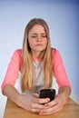 Scandinavian cute young girl looking irritated at her phone