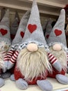 Scandinavian gnome in grey hat with red heart decorative christmas toy sitting in the supermarket, nobody