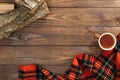 Scandinavian hygge style autumn flatlay composition. Frame of fashion feminine red scarf, cup of tea, firewood on wooden