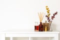 Scandinavian hygge style, home interior - aroma diffuser with wooden sticks, perfume, straw basket, dried eucalyptus branches Royalty Free Stock Photo