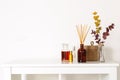 Scandinavian hygge style, home interior - aroma diffuser with wooden sticks, perfume, straw basket, dried eucalyptus branches