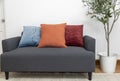 Scandinavian interior decoration of grey sofa with blue, red and orange pillow on it. Royalty Free Stock Photo