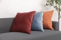 Scandinavian interior decoration of grey sofa with blue, red and orange pillow on it. Royalty Free Stock Photo