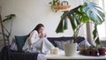 Scandinavian lifestyle - young beautiful woman resting on a couch, drinking coffee and enjoying life