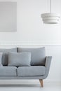 Living room sofa in white daily room interior with painting on the wall and lamp above Royalty Free Stock Photo