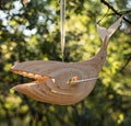 Scandinavian minimalist wooden handmade designer whale hanging on a tree in a green summer forest