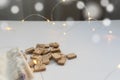 Scandinavian runes and a light sack lie on a white table with garland lights. The concept of Christmas fortune telling