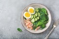 Scandinavian salad with smoked pink salmon, spinach, cucumber and chicken egg in gray ceramic dish. Royalty Free Stock Photo