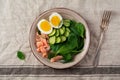 Scandinavian salad with smoked pink salmon, spinach, cucumber and chicken egg in gray ceramic dish. Top view Royalty Free Stock Photo