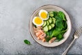 Scandinavian salad with smoked pink salmon, spinach, cucumber and chicken egg in gray ceramic dish. Top view Royalty Free Stock Photo