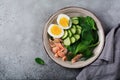 Scandinavian salad with smoked pink salmon, spinach, cucumber and chicken egg in gray ceramic dish. Top view Royalty Free Stock Photo