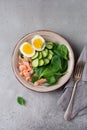 Scandinavian salad with smoked pink salmon, spinach, cucumber and chicken egg in gray ceramic dish. Top view Royalty Free Stock Photo