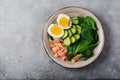 Scandinavian salad with smoked pink salmon, spinach, cucumber and chicken egg in gray ceramic dish. Top view. Toned image Royalty Free Stock Photo