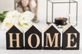 Flowers and lit candle, wooden letter Home Royalty Free Stock Photo