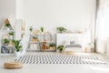 Scandinavian style, wooden furniture with plants and mountain decorations in a sunny, monochromatic child bedroom interior with wh